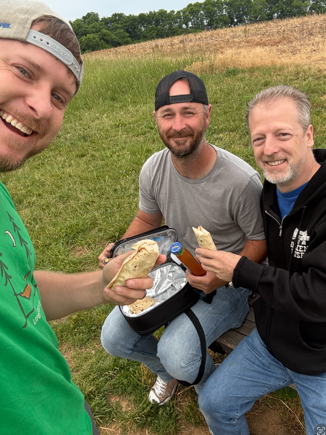 Three friends sharing food and laughter outdoors in Middle Tennessee